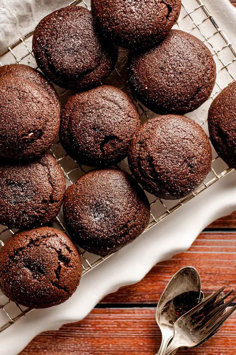 Chocolate Lava Cookies cooling on a wire rack, with a rich, dark chocolate exterior and scattered chocolate chips.