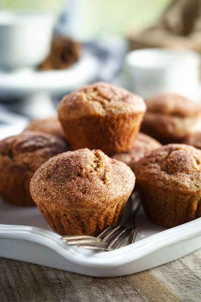 Cinnamon Muffins topped with cinnamon sugar, served on a white plate.