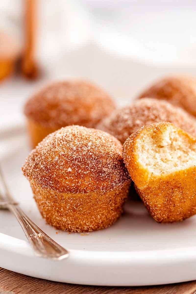 Partially eaten cinnamon sugar-coated muffin showcasing its soft, fluffy interior.