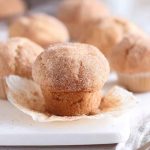 A golden-brown Cinnamon Sugar Doughnut Muffin dusted with cinnamon sugar, showcasing its soft, moist interior.