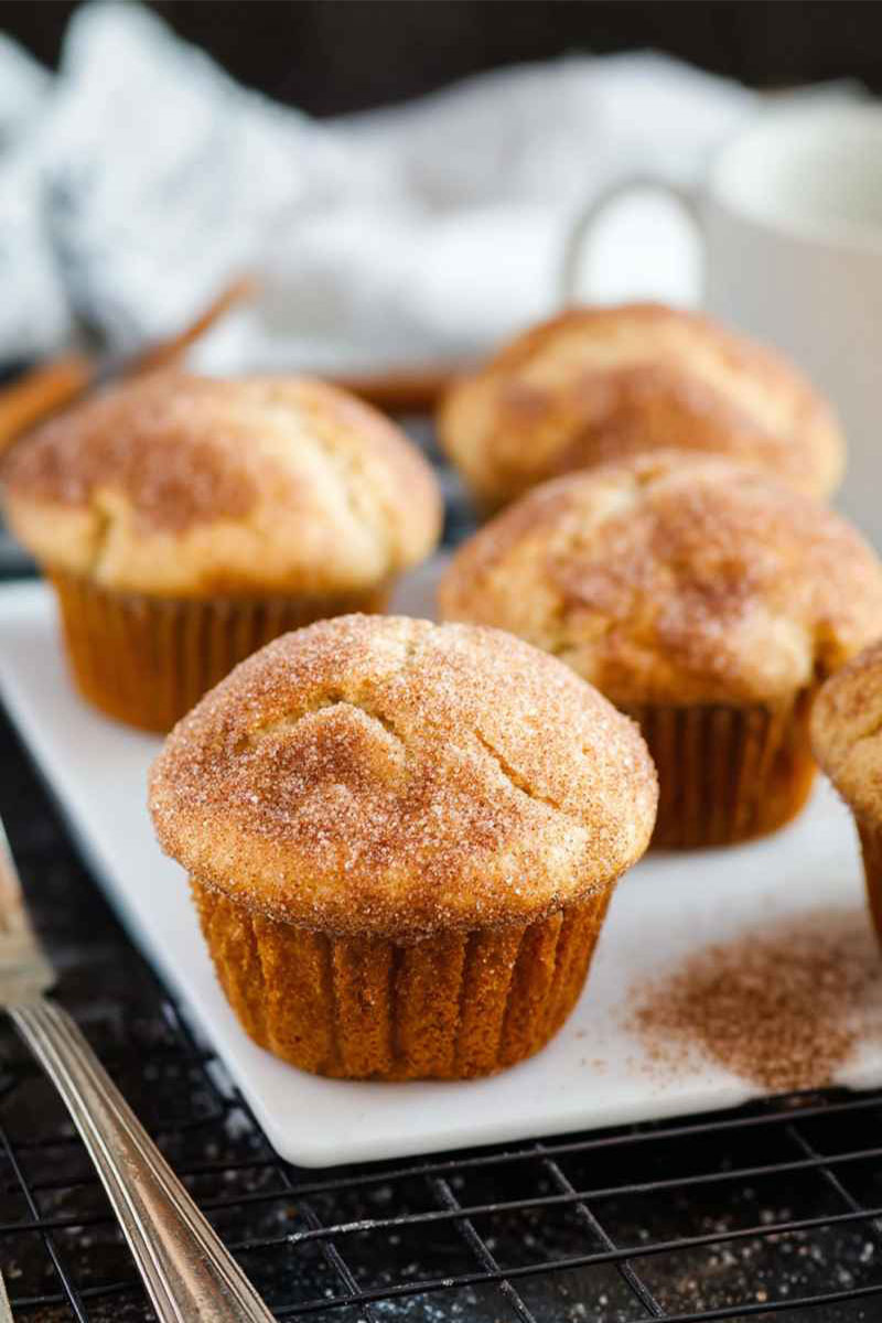 Close-up of Cinnamon Sugar Muffins on a white plate, highlighting their golden crust and sprinkle of cinnamon sugar.