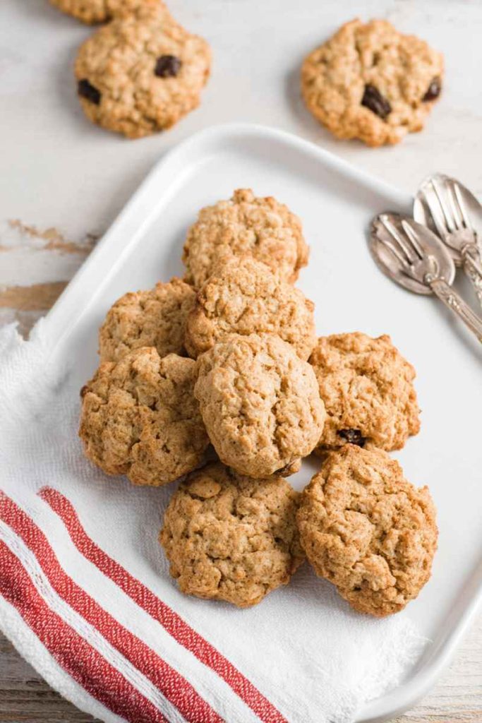 A plate of Nana's Oatmeal Cookies with golden-brown texture, oats, and raisins.