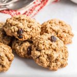 A stack of Nana's Oatmeal Cookies with golden-brown texture, oats, and raisins.
