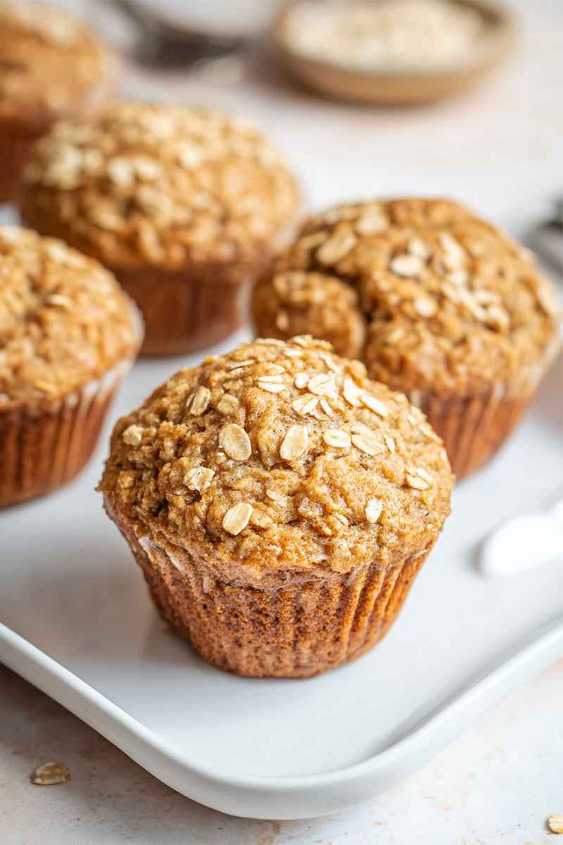 Delicious applesauce oatmeal muffins arranged on a white tray, showcasing their golden tops and crumbly texture.