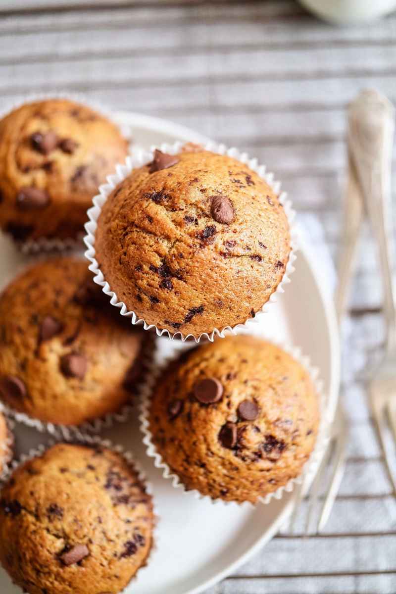 Golden-brown mocha muffins with visible chocolate chips, arranged on a cooling rack.