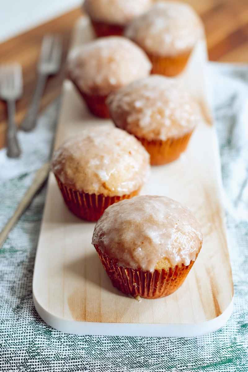 Golden-brown Old Fashioned Donut Muffins with a glossy glaze, arranged on a wooden serving board.