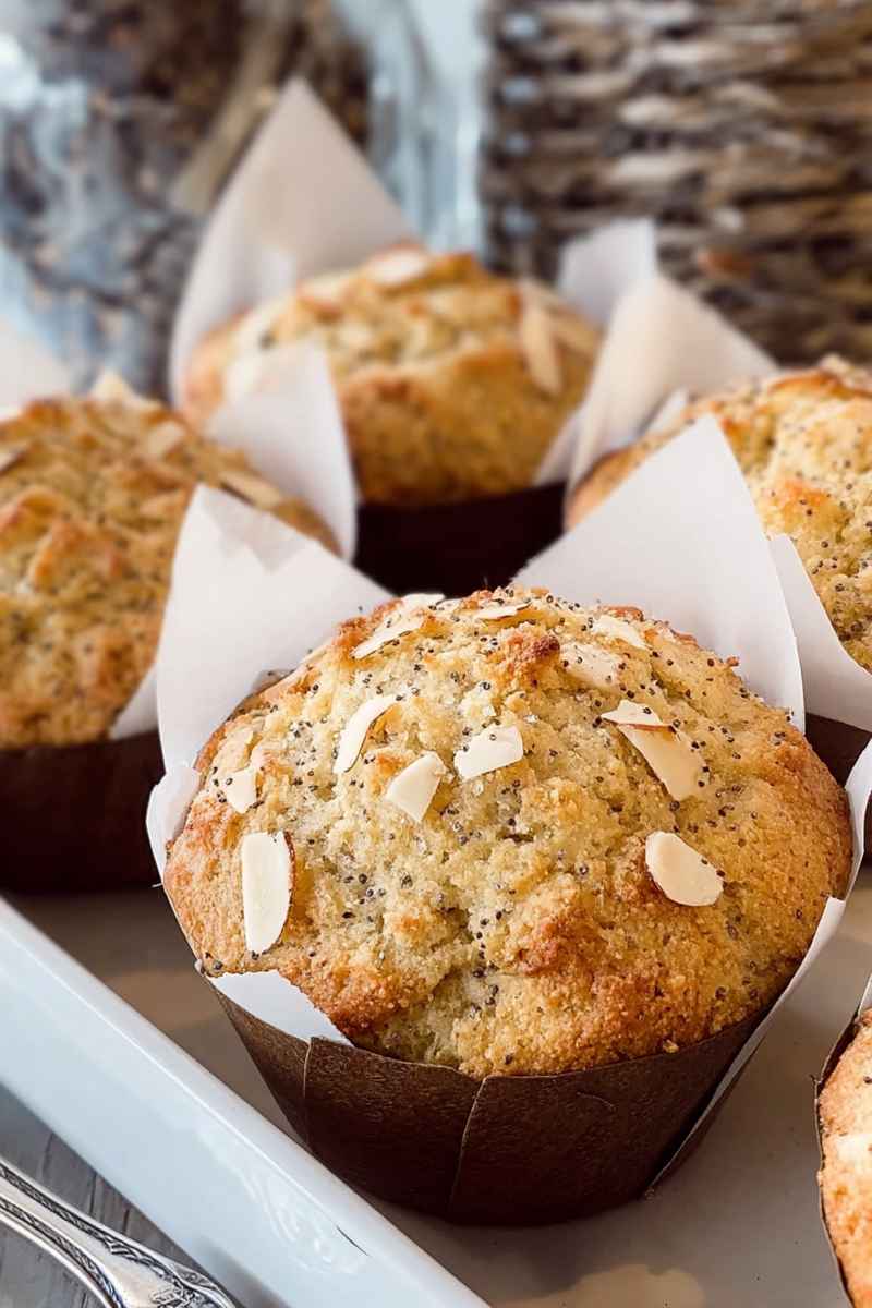 Moist Almond Poppy Seed Muffins with a golden, crumbly streusel topping.