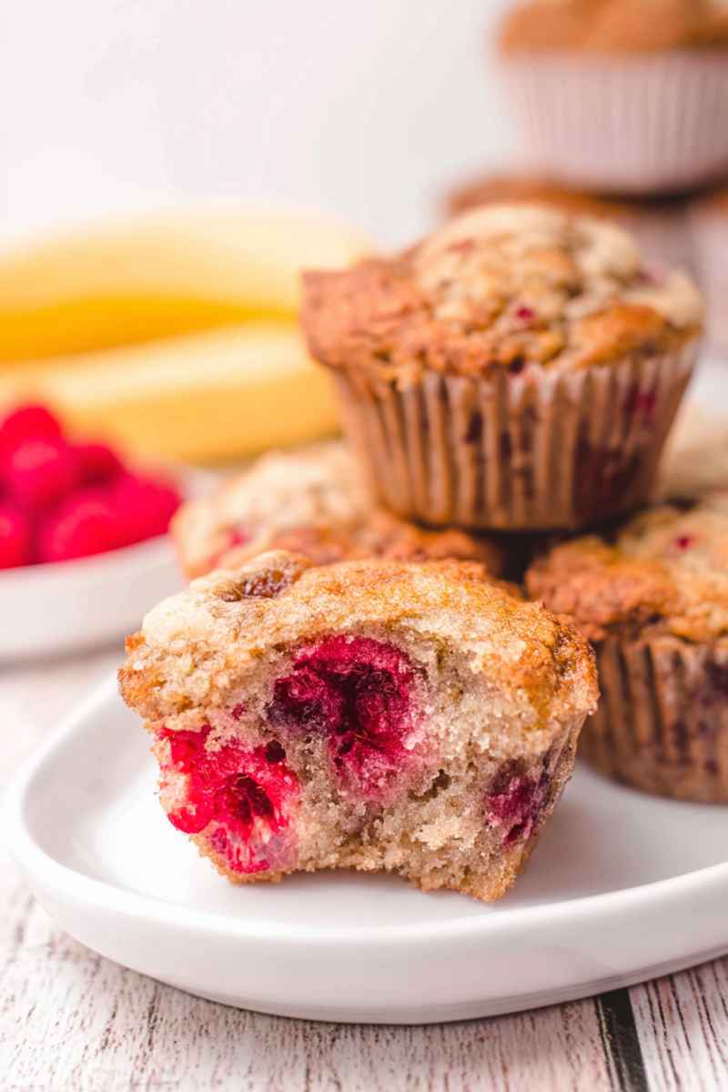 A halved banana raspberry muffin revealing a juicy raspberry jam filling.