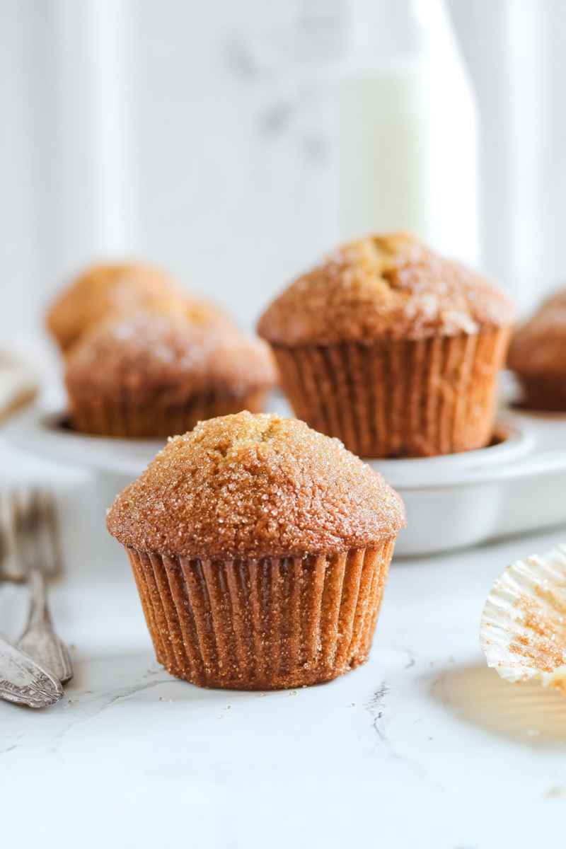 Golden brown sugar muffins arranged on a white plate, showcasing their rustic charm.