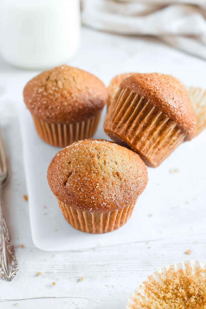Fluffy brown sugar muffins with a golden-brown exterior, displayed on a white plate.