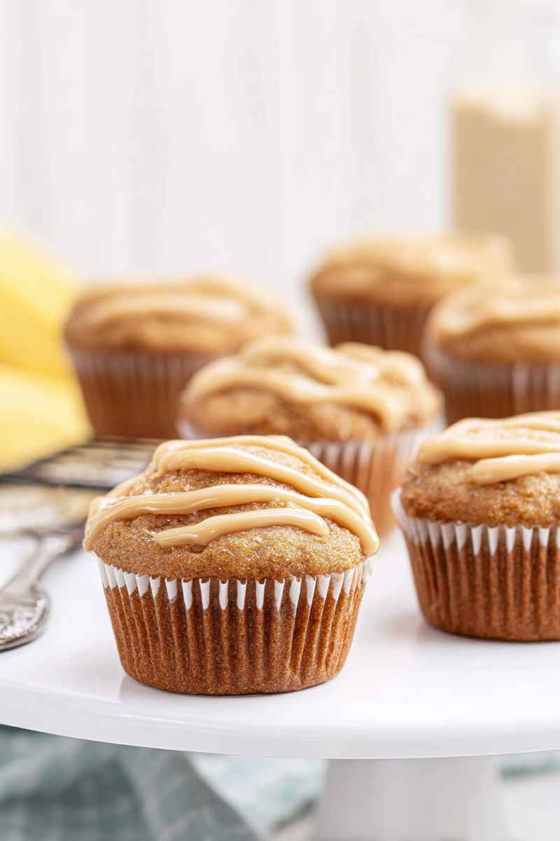 A plate of golden-brown caramel banana muffins with a glossy caramel drizzle.