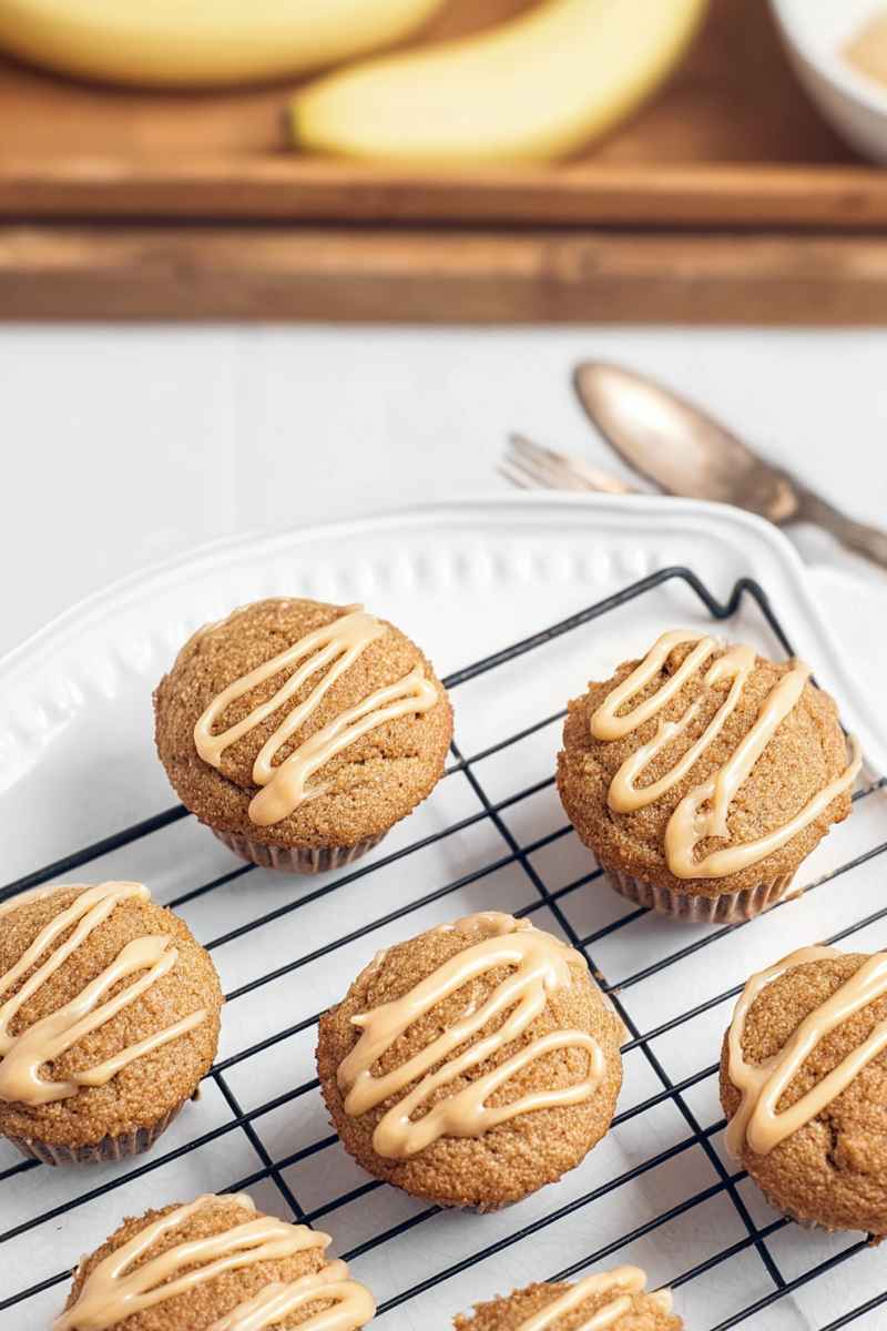 Caramel banana muffins cooling on a wire rack, topped with a creamy caramel drizzle.