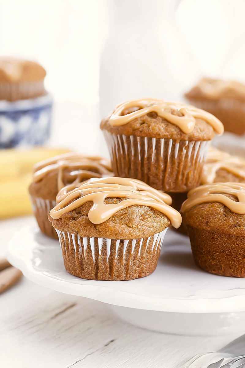 A close-up of caramel banana muffins with intricate caramel swirls on a white plate.