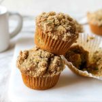 Close-up of stacked Cinnamon Zucchini Crumb Muffins, highlighting their fluffy texture and warm spices.