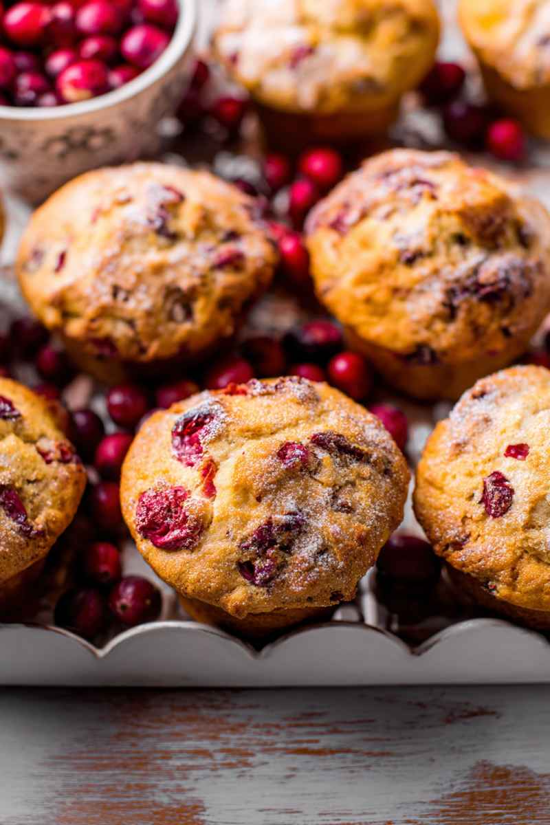 A cluster of Cranberry Orange Muffins surrounded by fresh cranberries, ready to be enjoyed.