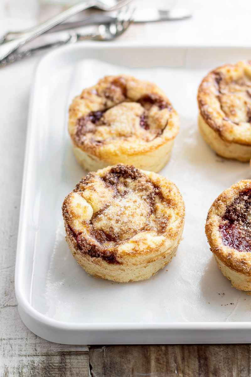 Creamy Jammy Coffee Cakes with layers of cake, cream cheese, jam, and streusel topping on a white tray.
