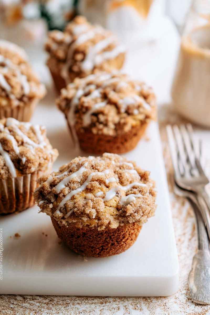 Fluffy Crumb Cake Muffins with a creamy texture, topped with cinnamon-sugar crumbs and a light icing drizzle.