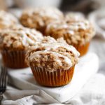 Chai Streusel Muffins arranged on a marble tray, with a cozy napkin and fork nearby.