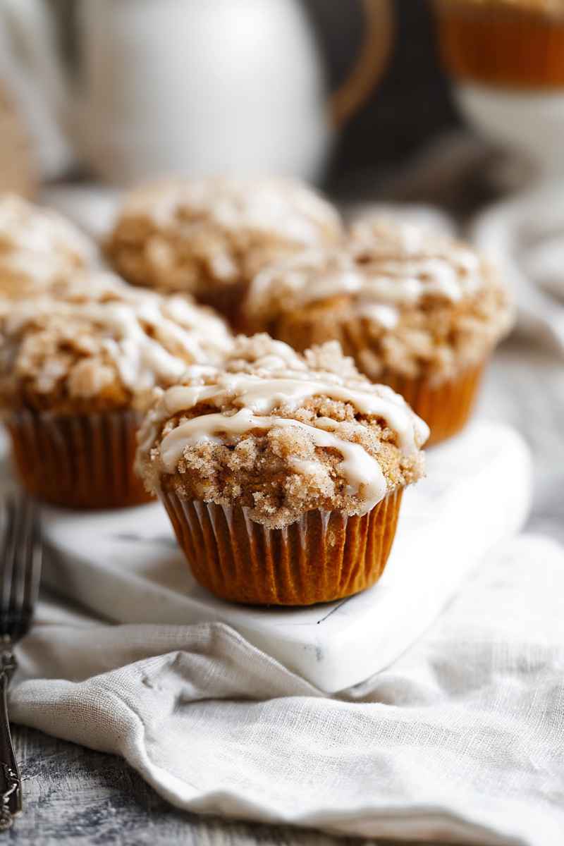 Chai Streusel Muffins arranged on a marble tray, with a cozy napkin and fork nearby.