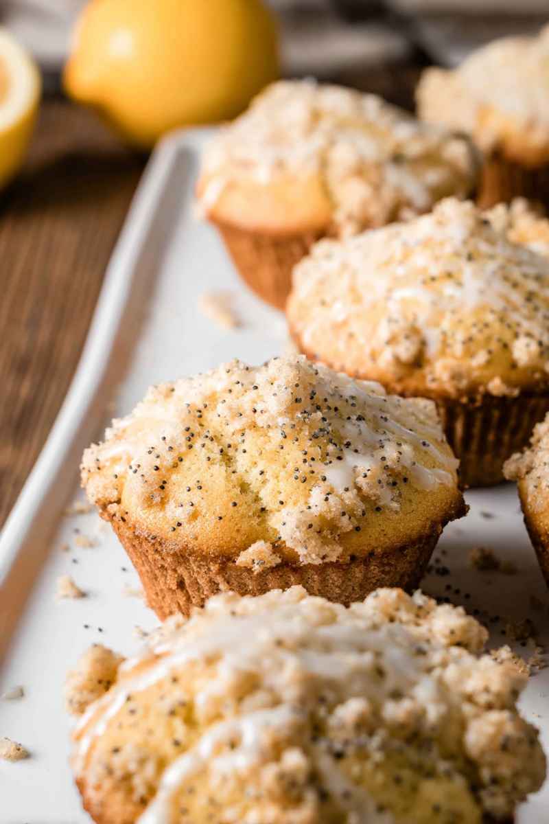 Lemon Poppy Seed Muffins with a generous layer of crumbly streusel topping, served on a white plate.