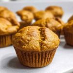 A plate of golden pumpkin protein muffins, showcasing their warm spices and inviting appearance.