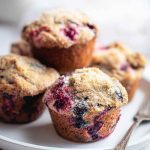 A plate of mixed berry muffins, showcasing their golden-brown tops and colorful berry fillings, ready to be enjoyed.