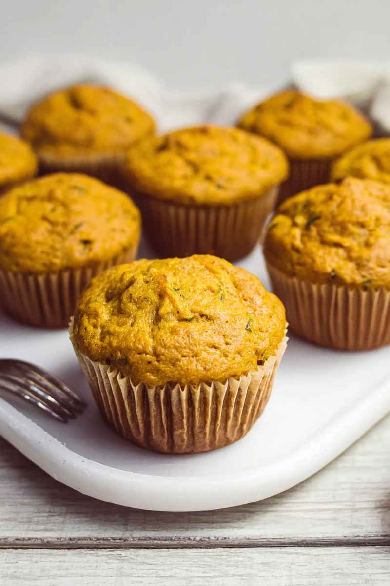 A plate of freshly baked pumpkin zucchini muffins, ready to enjoy.